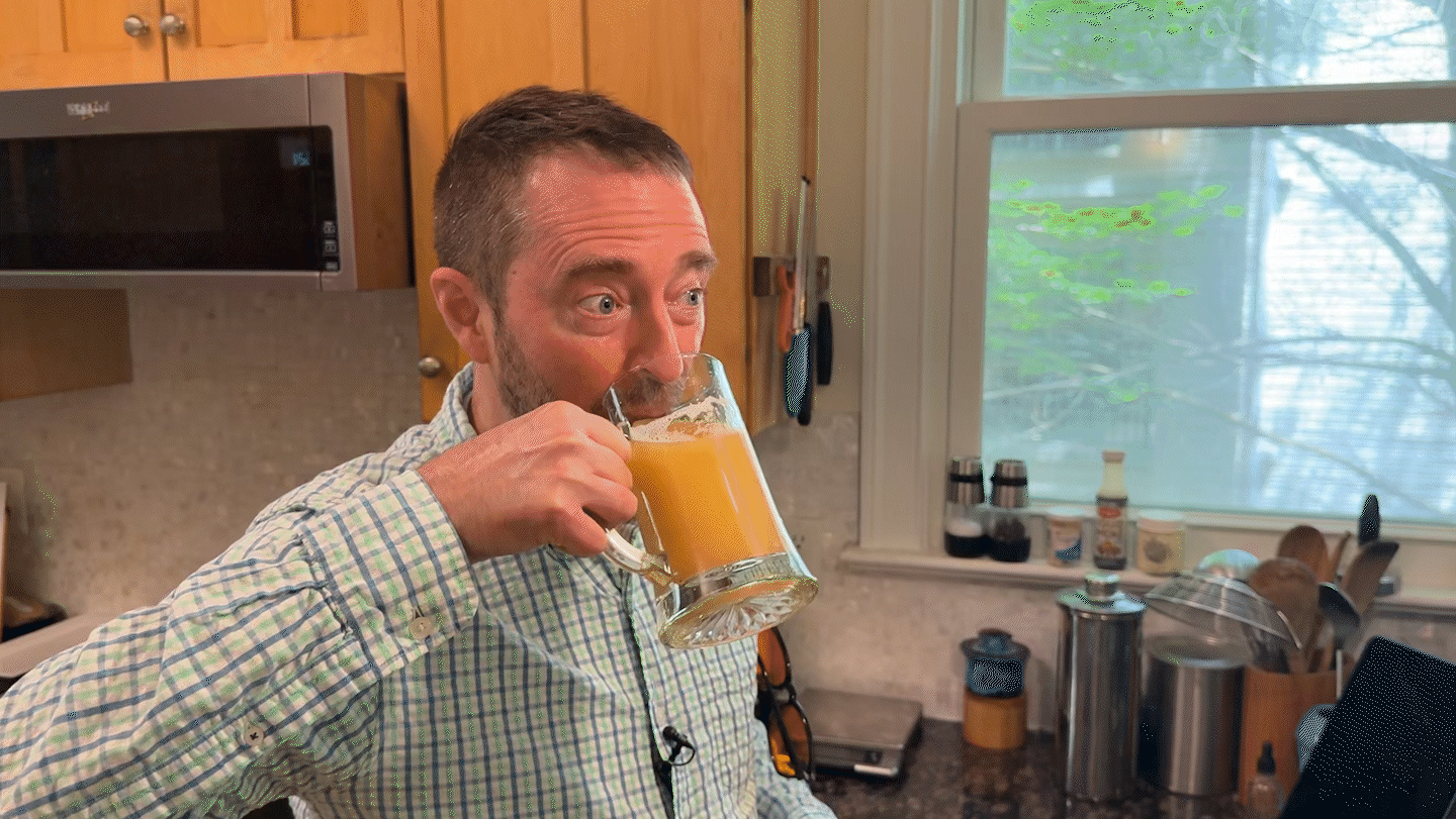 A man takes a sip of beer and has a delighted look on his face.