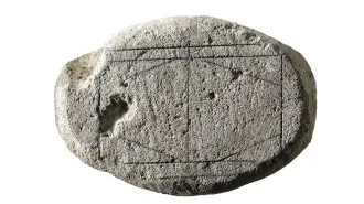 A game “board” on a piece of limestone solved by AI