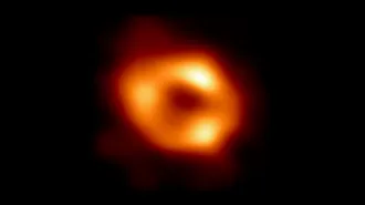 An image of a black hole, showing a bright orange circle in the middle of a dark exterior.
